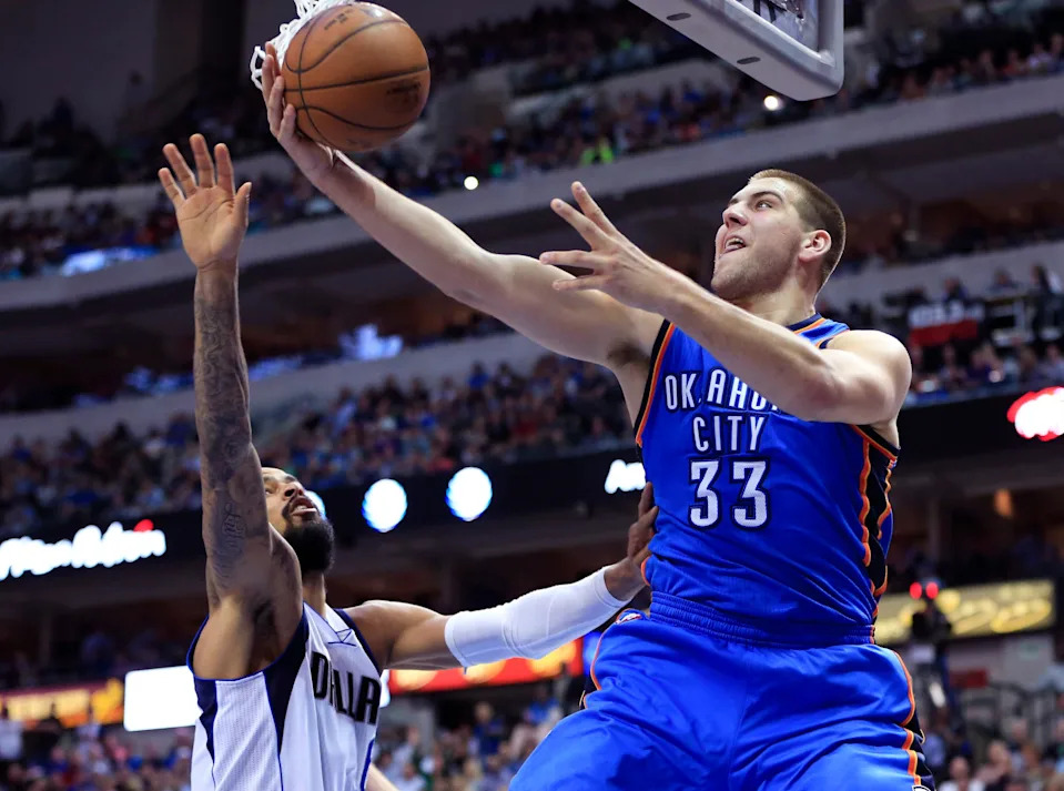 Mar 16, 2015; Dallas, TX, USA; Oklahoma City Thunder forward Mitch McGary (33) shoots around Dallas Mavericks center Tyson Chandler (6) during the game at American Airlines Center. Dallas won 119-115. Mandatory Credit: Kevin Jairaj-USA TODAY Sports