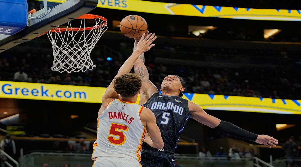 Orlando Magic forward Paolo Banchero, right, tries to shoot over Atlanta Hawks guard Dyson Daniels, left, during the second half of an NBA basketball game, Tuesday, April 8, 2025, in Orlando, Fla. (AP Photo/John Raoux)