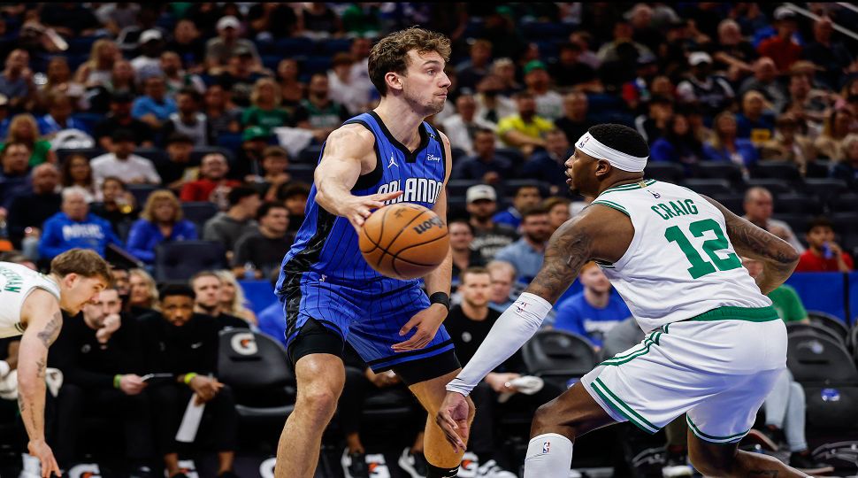 Orlando Magic forward Franz Wagner, left, passes the ball around Boston Celtics forward Torrey Craig (12) during the first half of an NBA basketball game, Wednesday, April 9, 2025, in Orlando, Fla. (AP Photo/Kevin Kolczynski)