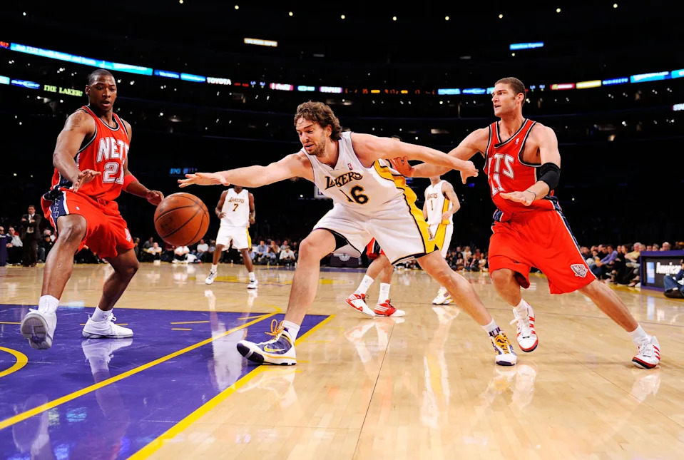 LOS ANGELES, CA - NOVEMBER 29: Pau Gasol #16 of the Los Angeles Lakers reaches for a the ball against Brook Lopez #11 and Bobby Simmons #21 of the New Jersey Nets during the second quarter of the NBA basketball game at Staples Center on November 29, 2009 in Los Angeles, California. NOTE TO USER: User expressly acknowledges and agrees that, by downloading and/or using this Photograph, user is consenting to the terms and conditions of the Getty Images License Agreement. (Photo by Kevork Djansezian/Getty Images)