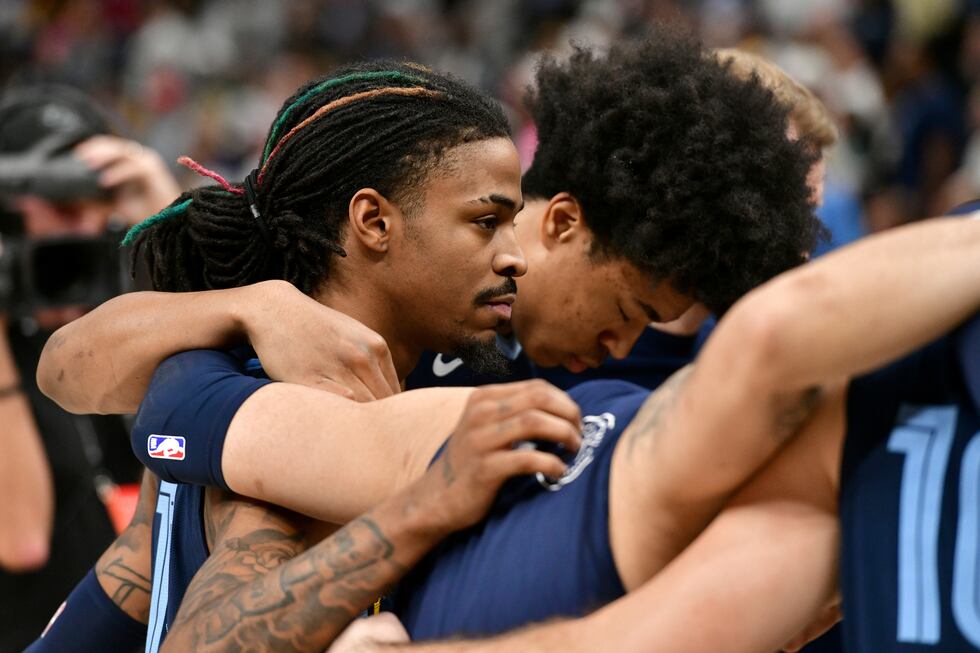Memphis Grizzlies guard Ja Morant, left, forward Jaylen Wells huddle with their team after a...