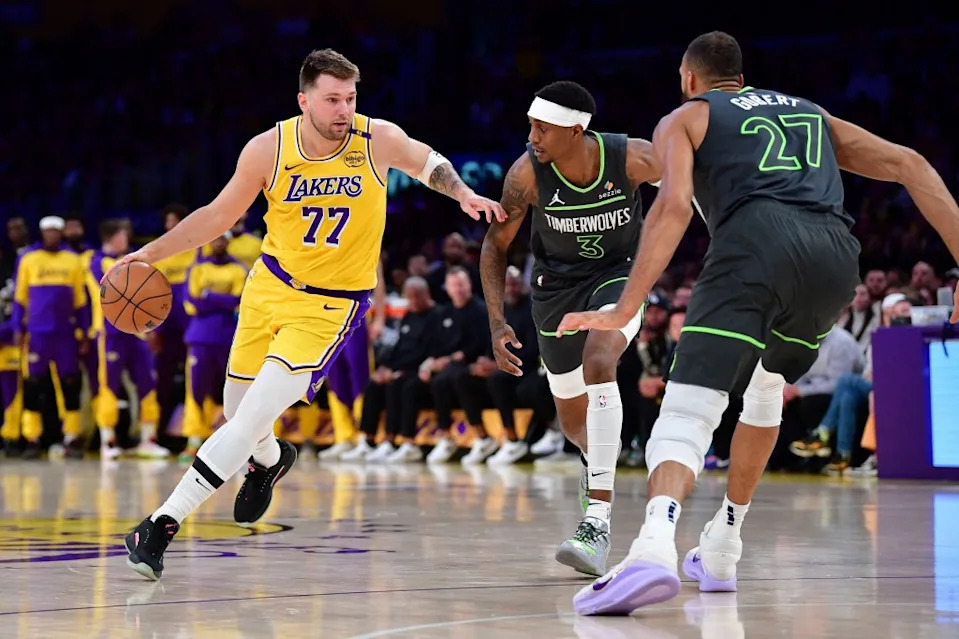 Los Angeles Lakers guard Luka Doncic (77) moves the ball against Minnesota Timberwolves forward Jaden McDaniels (3) and center Rudy Gobert (27) during the first half in game five of first round for the 2025 NBA Playoffs at Crypto.com Arena. IMAGN IMAGES via Reuters Connect