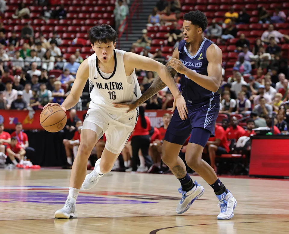 LAS VEGAS, NEVADA - JULY 12: Yang Hansen #16 of the Portland Trail Blazers drives against Armando Bacot #00 of the Memphis Grizzlies in the first half of a 2025 NBA Summer League game at the Thomas & Mack Center on July 12, 2025 in Las Vegas, Nevada. NOTE TO USER: User expressly acknowledges and agrees that, by downloading and or using this photograph, User is consenting to the terms and conditions of the Getty Images License Agreement. (Photo by Ethan Miller/Getty Images)