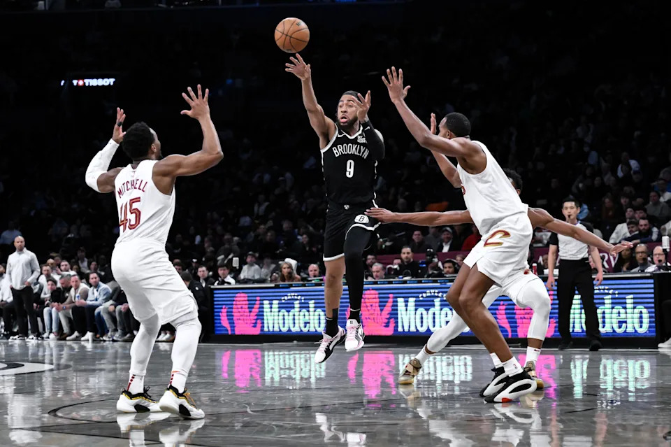 Feb 20, 2025; Brooklyn, New York, USA; Brooklyn Nets forward Trendon Watford (9) passes the ball as Cleveland Cavaliers guard Donovan Mitchell (45) and forward Evan Mobley (4) defend during the first half at Barclays Center. Mandatory Credit: John Jones-Imagn Images