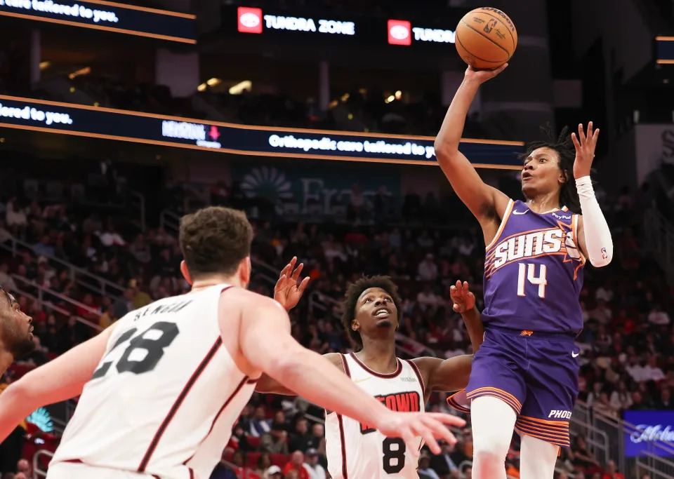 Phoenix Suns guard TyTy Washington Jr. (14) shoots against Houston Rockets forward Jae'Sean Tate (8) in the second quarter at Toyota Center in Houston on Feb. 12, 2025.