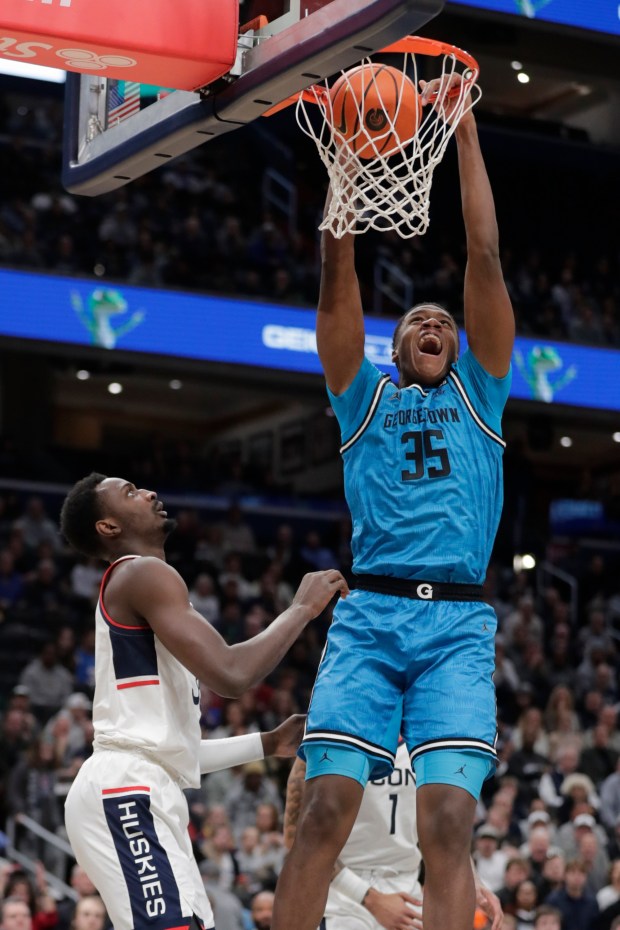 Georgetown's Thomas Sorber (35) dunks the ball over Connecticut's Samson Johnson during the first half of an NCAA college basketball game, Saturday, Jan. 11, 2025, in Washington.(AP Photo/Luis M. Alvarez)