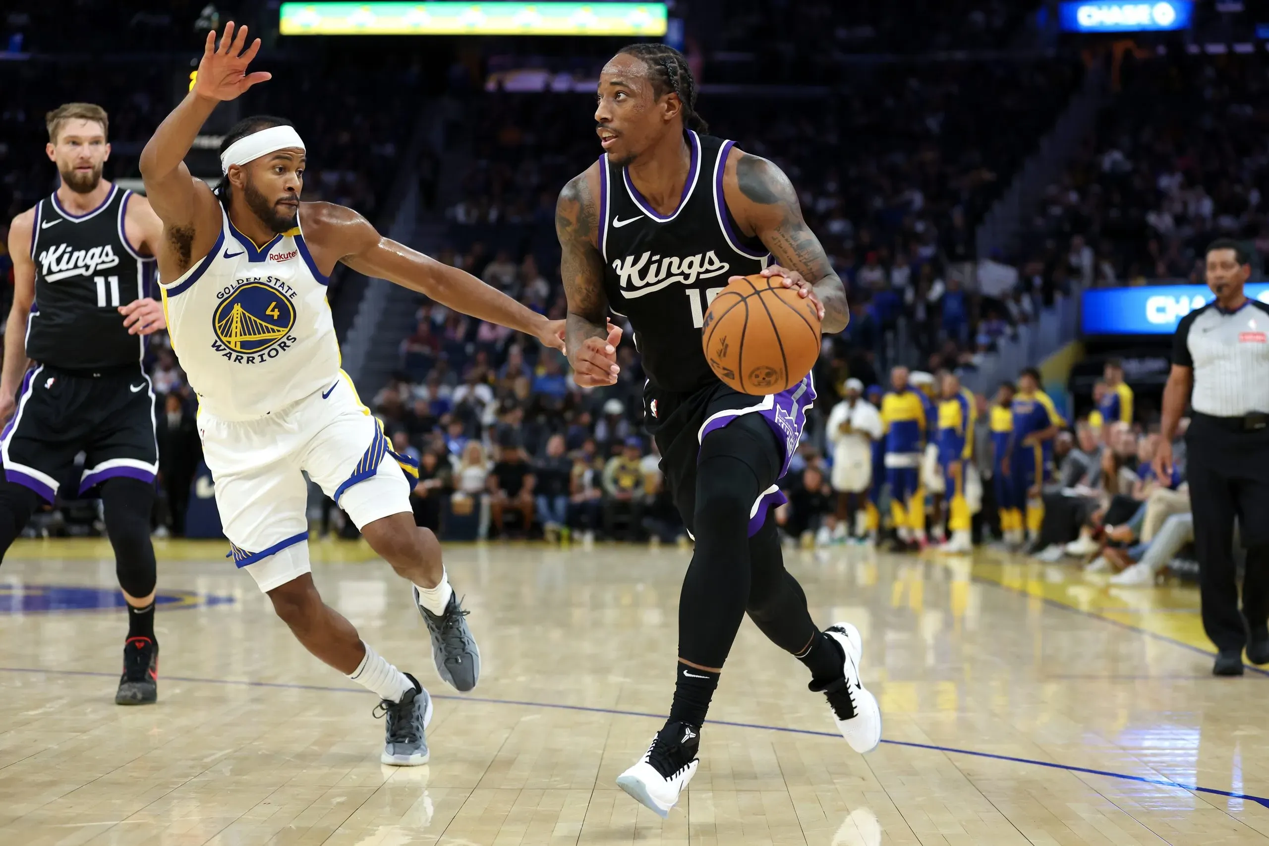 DeMar DeRozan #10 of the Sacramento Kings is guarded by Moses Moody #4 of the Golden State Warriors during the first half of their preseason game at Chase Center on October 11, 2024 in San Francisco, California.