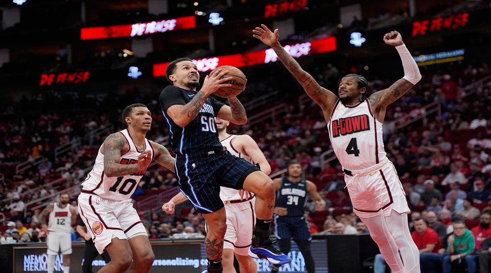 Orlando Magic's Cole Anthony (50) goes up for a shot as Houston Rockets' Jalen Green (4) defends during the first half of an NBA basketball game Monday, March 10, 2025, in Houston. (AP Photo/David J. Phillip)