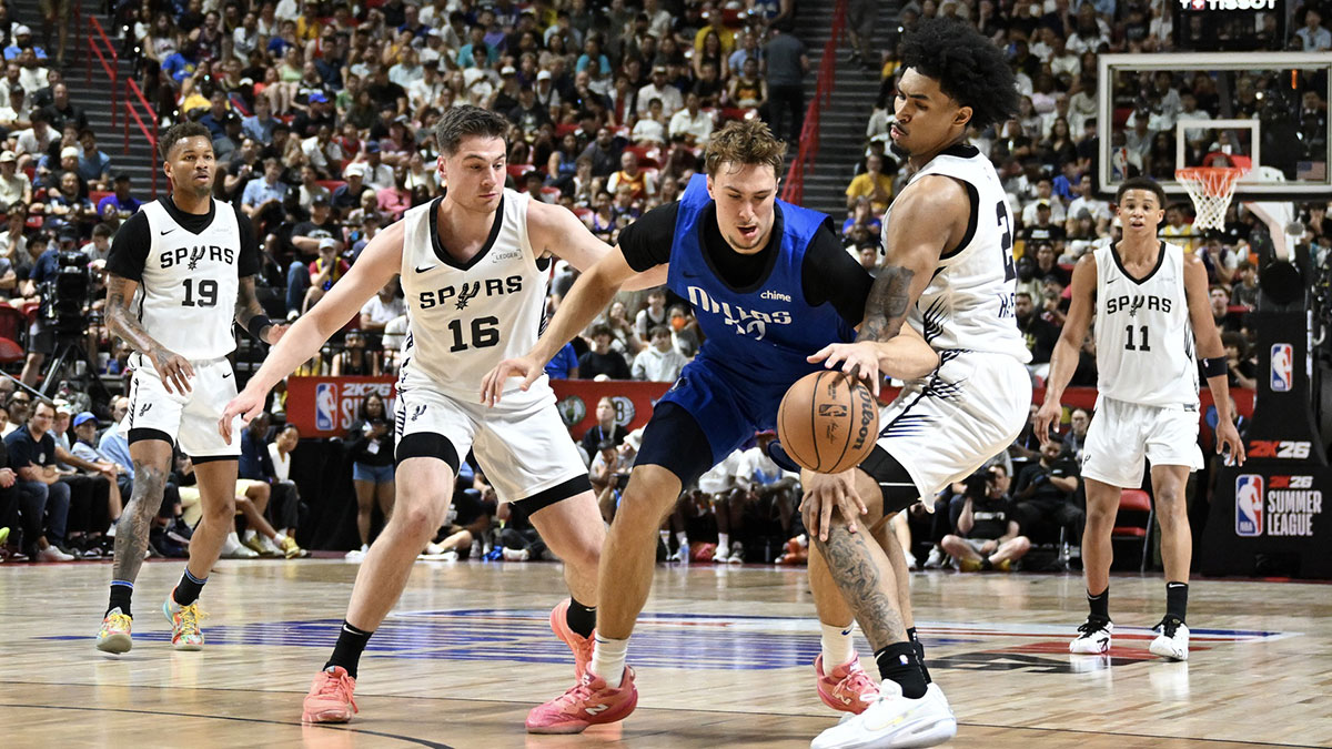 Dallas Mavericks forward Cooper Flagg (32) dribbles against San Antonio Spurs guard Kyle Mangas (16) and guard Dylan Harper (2) in the second quarter of their game at Thomas & Mack Center.