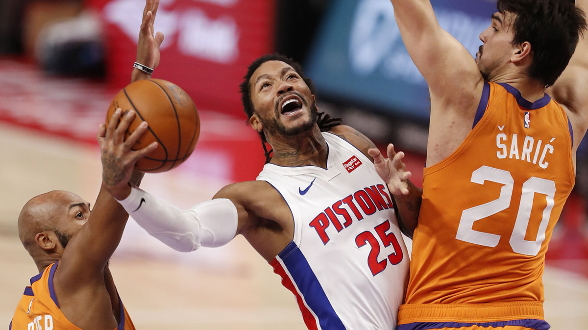 Detroit Pistons guard Derrick Rose (25) goes up for a shot against Phoenix Suns guard Jevon Carter (4) and forward Dario Saric (20) during the second quarter at Little Caesars Arena.