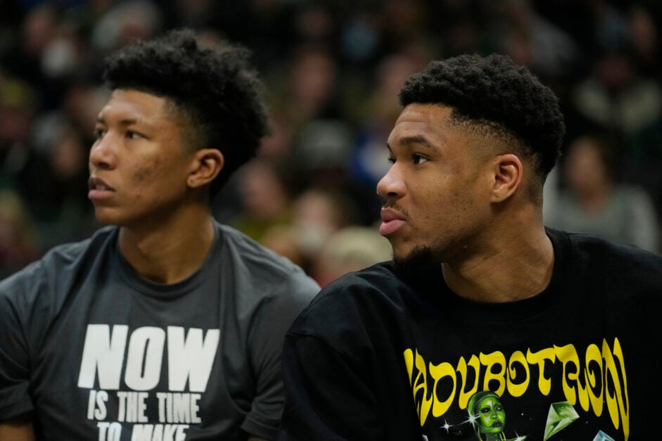 Giannis Antetokounmpo #34 and MarJon Beauchamp #0 of the Milwaukee Bucks watch play from the bench against the Indiana Pacers.
