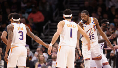Kevin Durant #35 of the Phoenix Suns high fives Bradley Beal #3 and Devin Booker #1 during the seco...