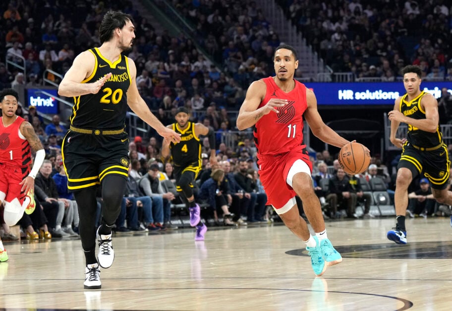 Malcolm Brogdon #11 of the Portland Trail Blazers drives to the basket on Dario Saric #20 of the Golden State Warriors during the first half of an NBA basketball game at Chase Center on December 23, 2023 in San Francisco, California.