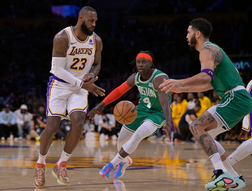 LeBron James #23 of the Los Angeles Lakers is guarded by Jrue Holiday #4 and Jayson Tatum #0 of the Boston Celtics at Crypto.com Arena on December 25, 2023 in Los Angeles, California.