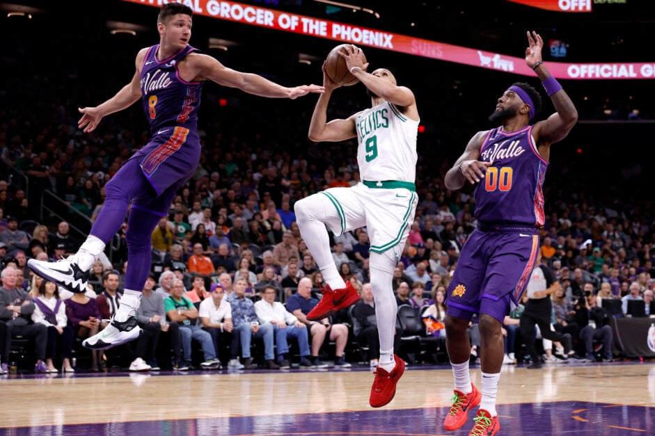 Grayson Allen #8 and Royce O'Neale #00 of the Phoenix Suns defend against Boston Celtics' Derrick White.