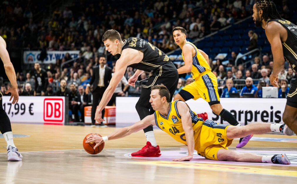 Luka Scucka reaches down to get the ball, wearing black uniform