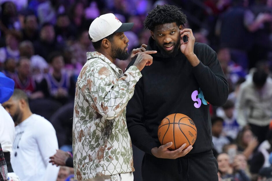 Paul George and Joel Embiid watch the Philadelphia 76ers from the sidelines