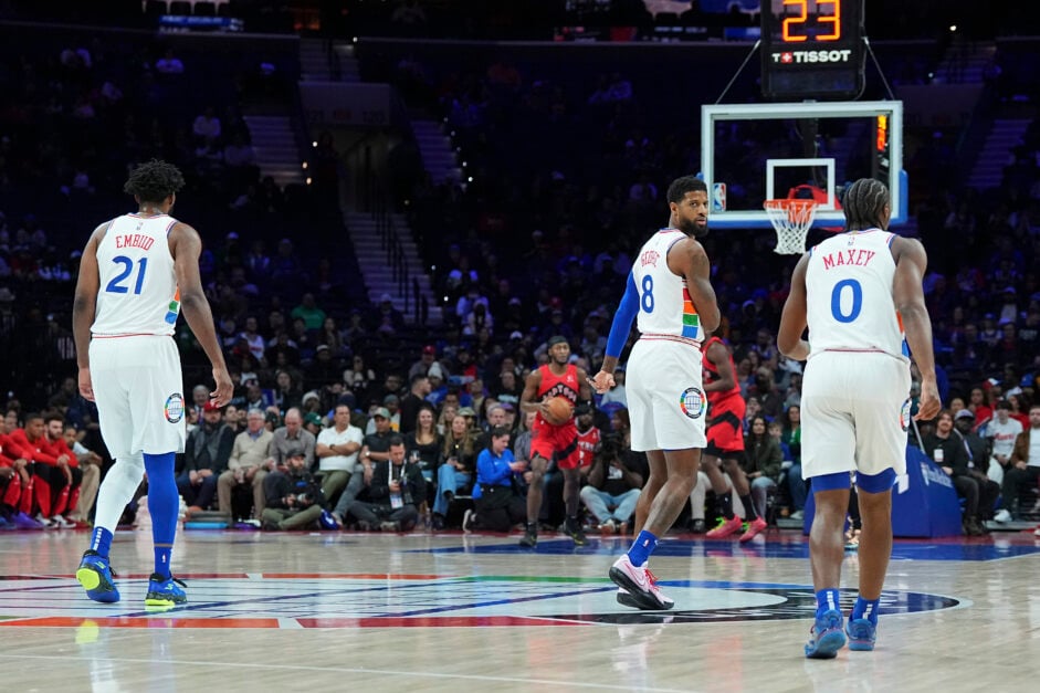 Philadelphia 76ers stars Tyrese Maxey, Joel Embiid, and Paul George pose at midcourt