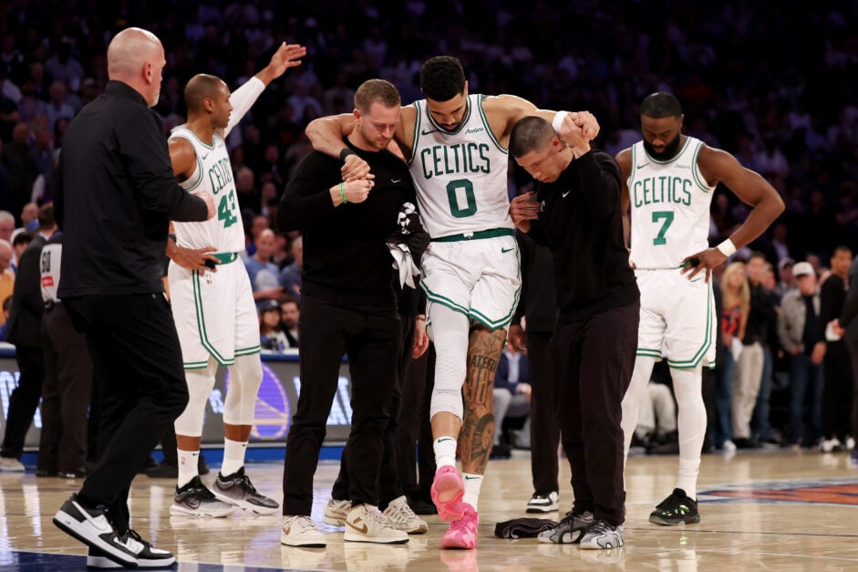 Jayson Tatum #0 of the Boston Celtics is assisted off court after being injured against the New York Knicks