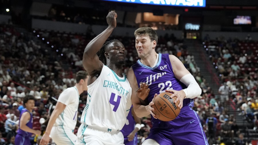 Kyle Filipowski #22 of the Utah Jazz collides with Sion James #4 of the Charlotte Hornets...