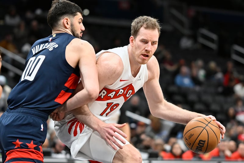 Toronto Raptors center Jakob Poeltl, right, drives to the basket against Washington Wizards forward Tristan Vukcevic (00) during game Monday, March 24, 2025, in Washington.
