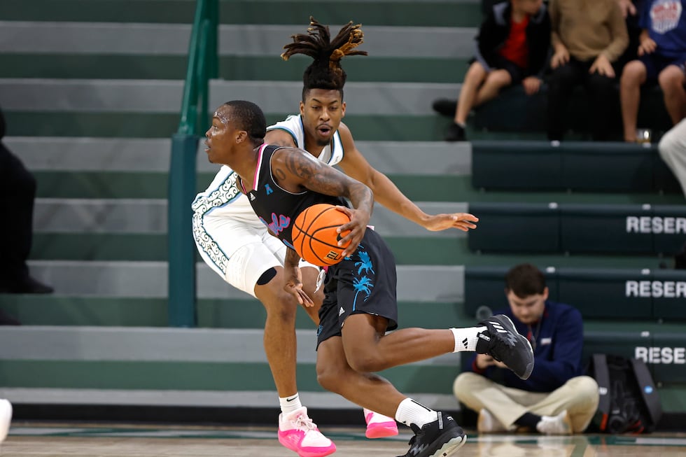 Florida Atlantic guard Johnell Davis, left, drives to the basket as Tulane forward Gregg Glenn...