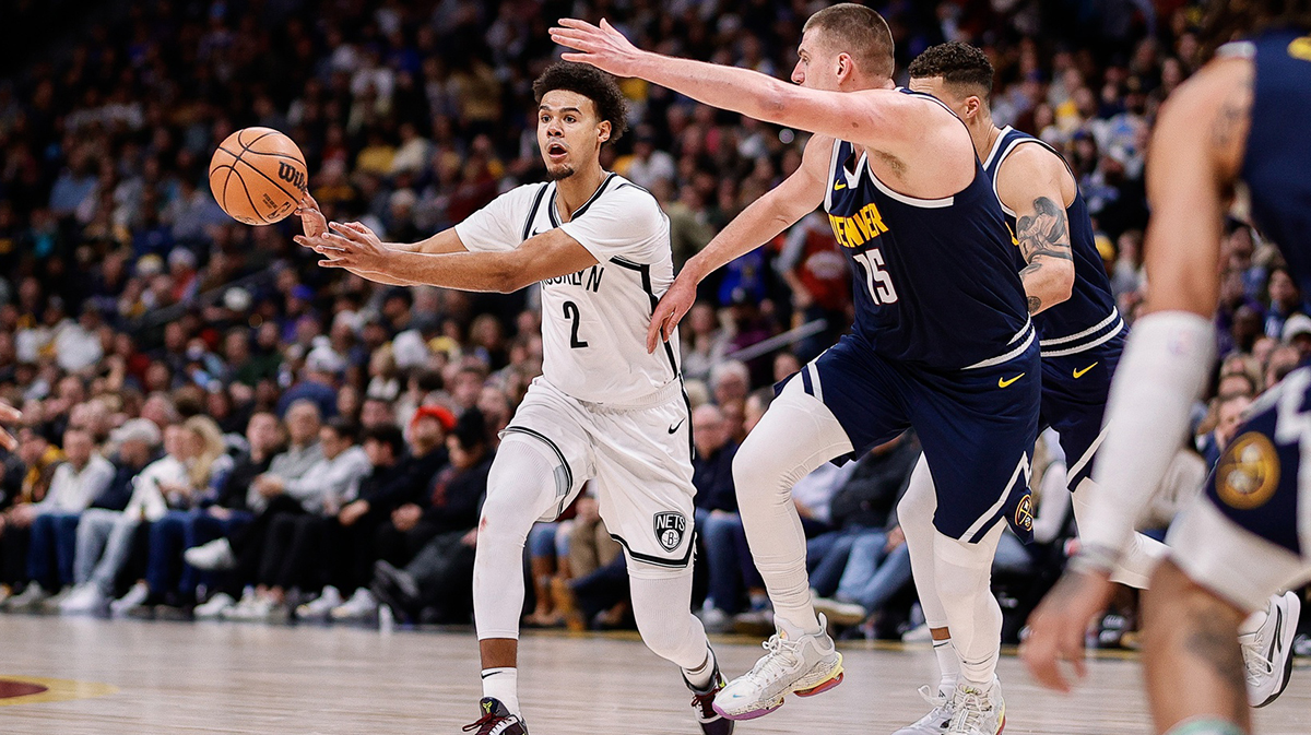 Brooklyn Nets forward Cam Johnson (2) passes the ball as Denver Nuggets center Nikola Jokic (15) guards in the second quarter at Ball Arena.