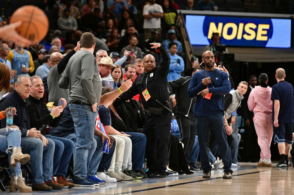 A police officer motions for help as a man has a medical emergency before an NBA basketball...