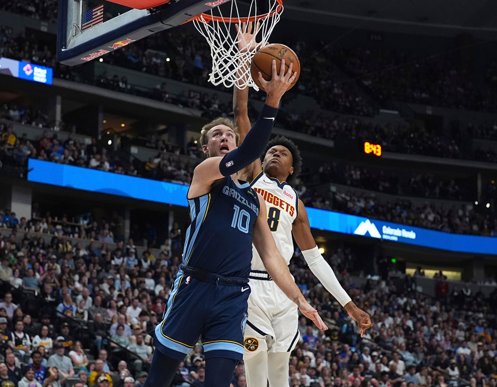 Memphis Grizzlies guard Luke Kennard, front, goes up for a basket as Denver Nuggets forward Peyton Watson defends in the second half of an NBA basketball game Friday, April 11, 2025, in Denver. (AP Photo/David Zalubowski)