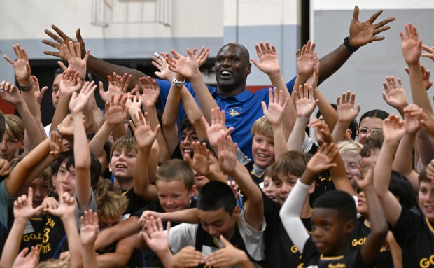 Former Warriors player Adonal Foyle takes a group photo with...