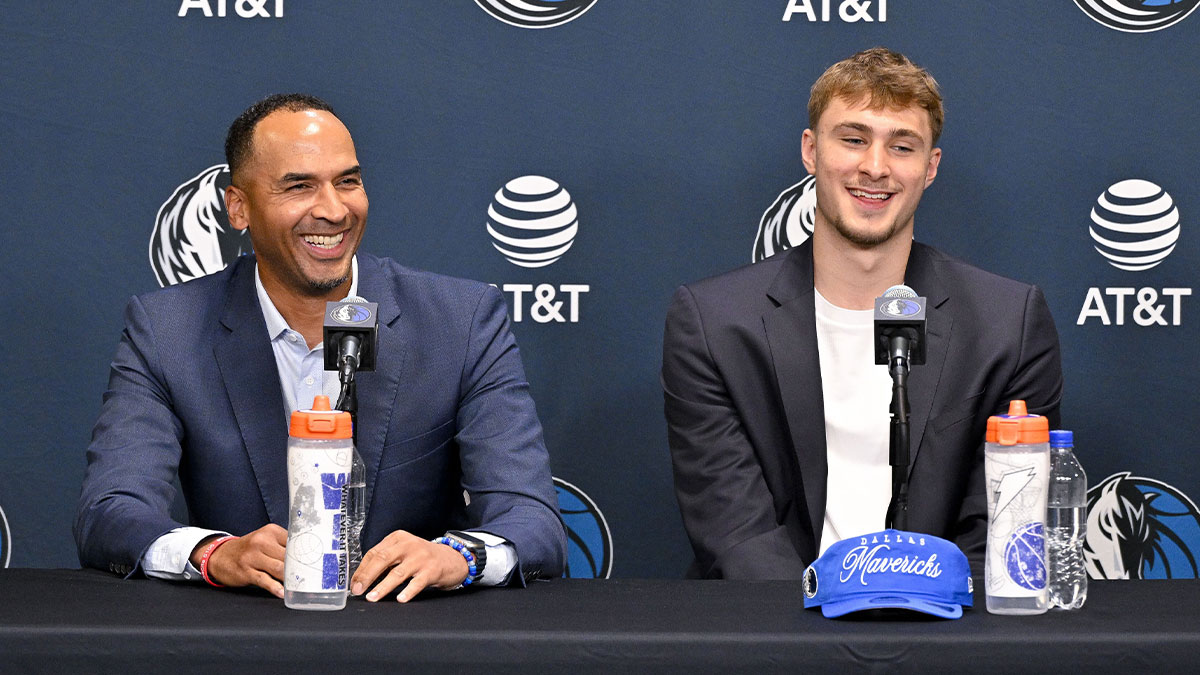 Mavericks general manager Nico Harrison (left) looks on with Mavericks first overall pick Cooper Flagg (right) at a press conference at the Dallas Mavericks Practice Facility with Mavericks' Anthony Davis and Mavericks' Kyrie Irving in the background