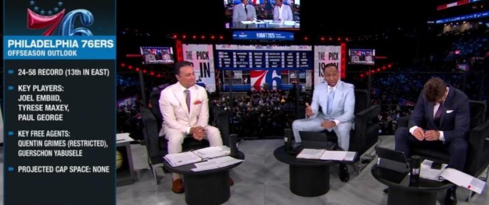 Three men in suits discussing the Philadelphia 76ers off-season outlook.
