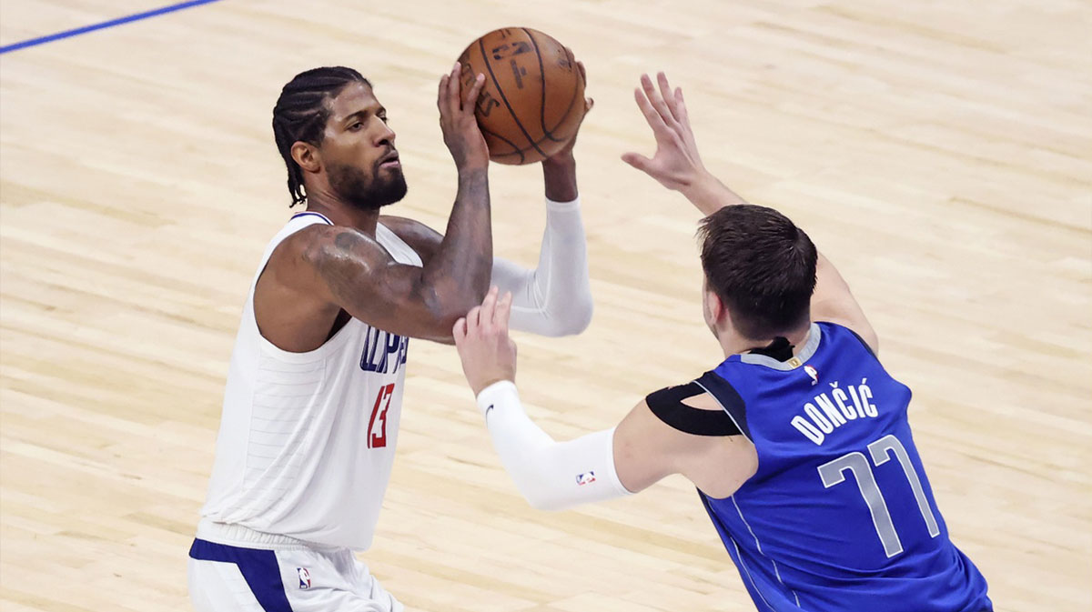 LA Clippers guard Paul George (13) shoots as Dallas Mavericks guard Luka Doncic (77) defends during the fourth quarter during game six in the first round of the 2021 NBA Playoffs at American Airlines Center.