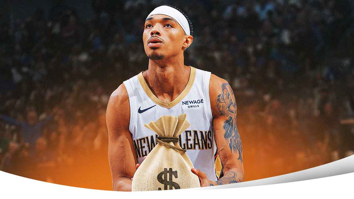 Pelicans' Brandon Boston Jr. smiling while holding a bag of money