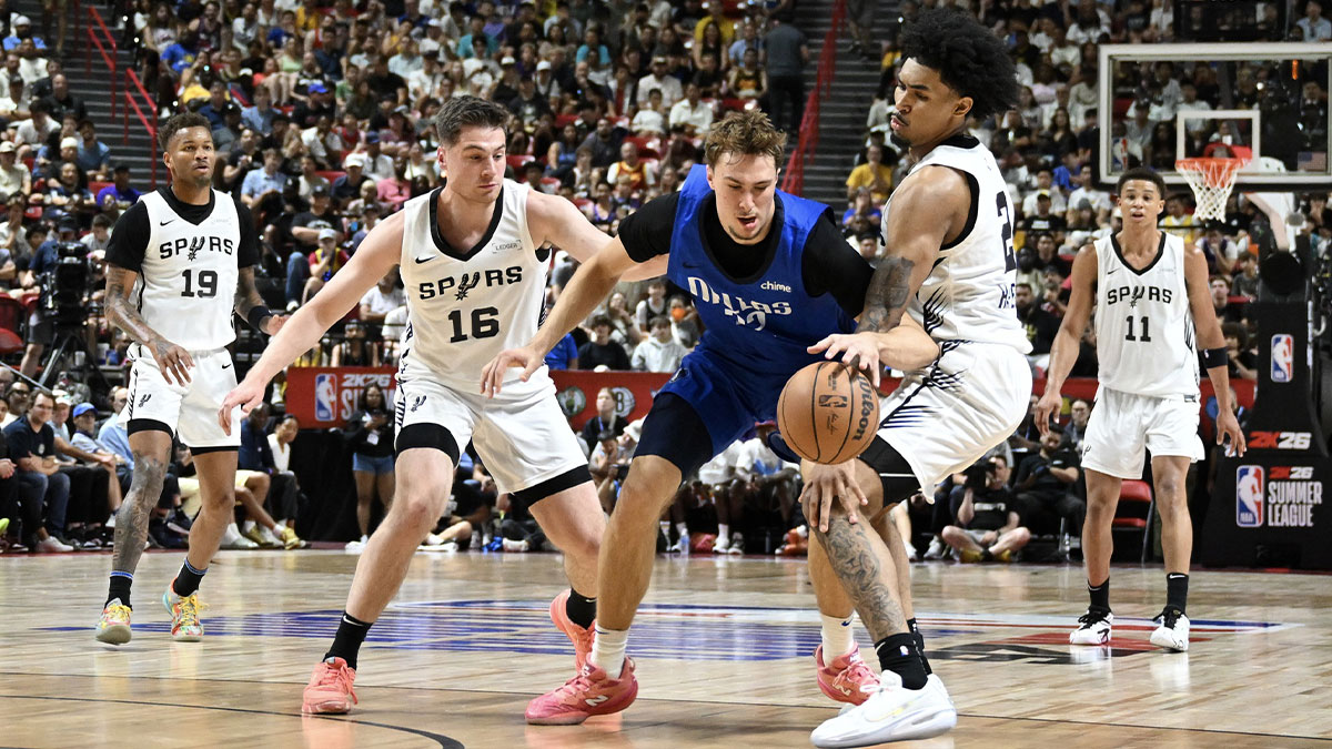 Dallas Mavericks forward Cooper Flagg (32) dribbles against San Antonio Spurs guard Kyle Mangas (16) and guard Dylan Harper (2) in the second quarter of their game at Thomas & Mack Center.