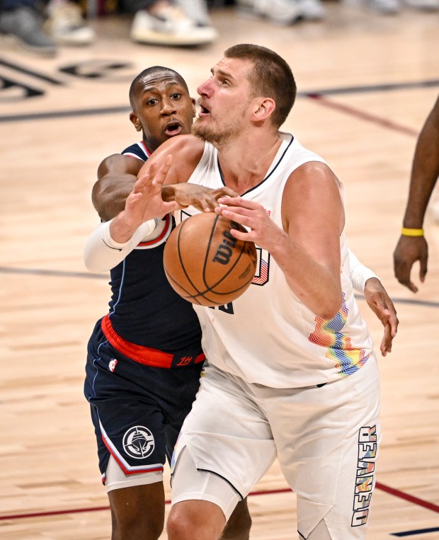 Kris Dunn (8) of the LA Clippers defends Nikola Jokic...