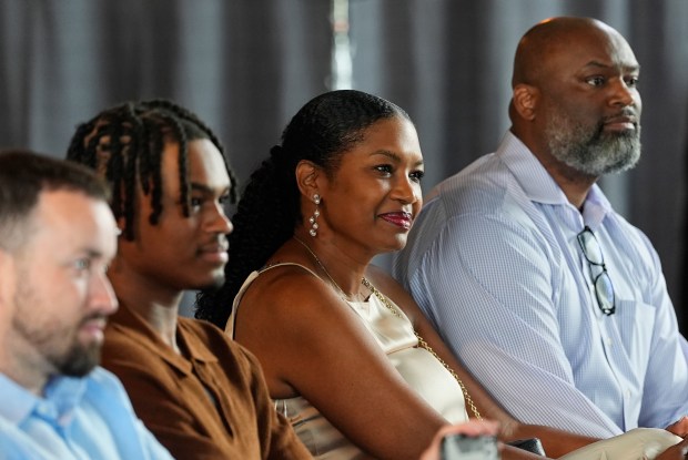 Tomika Holmes, center, mother of Denver Nuggets 2024 first-round draft pick DaRon Holmes II, looks on with her husband, DaRon, Sr., right, and son Quintyn, during an introductory NBA basketball news conference Monday, July 1, 2024, in Denver. (AP Photo/David Zalubowski)