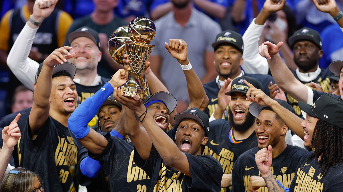 Thunder forward Jalen Williams (8) holds up the Bill Russell NBA Finals MVP trophy after winner Oklahoma City Thunder guard Shai Gilgeous-Alexander hands it to him at the end of game seven of the 2025 NBA Finals against the Indiana Pacers at Paycom Center