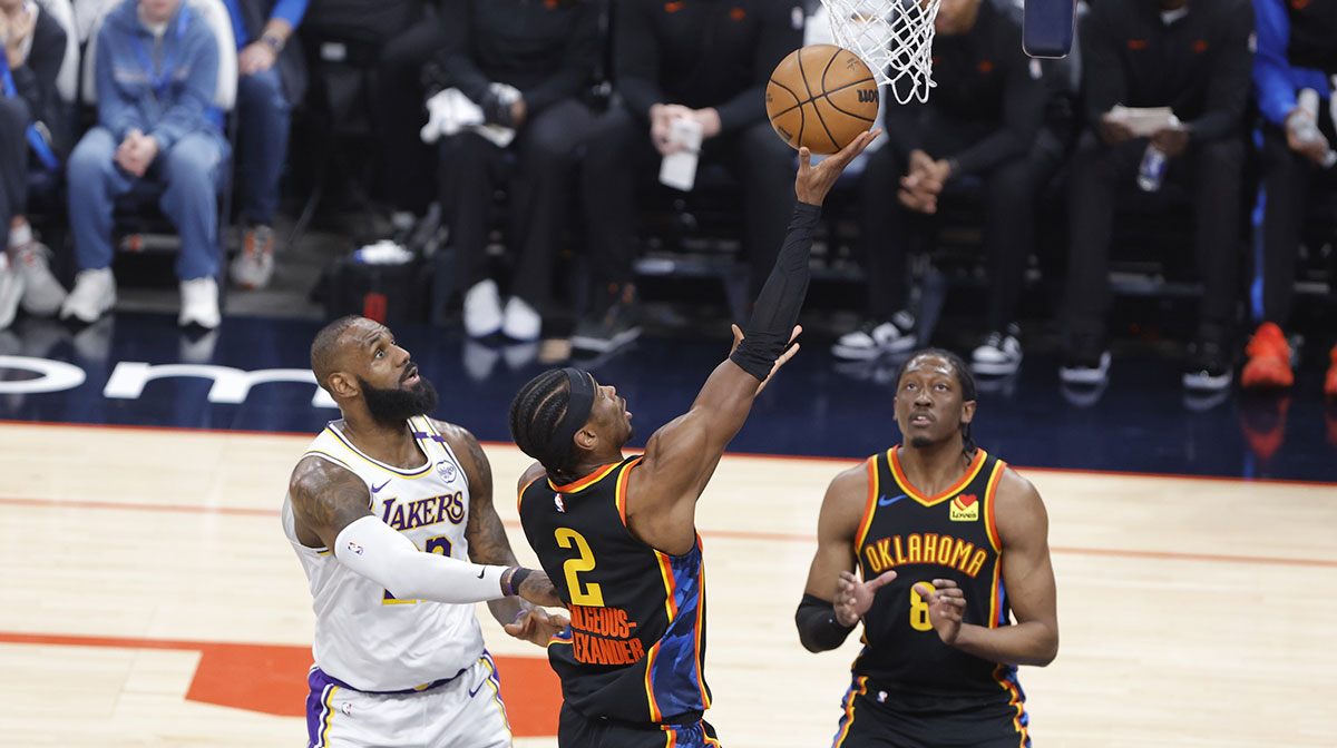 Thunder guard Shai Gilgeous-Alexander (2) goes up for a basket in front of Los Angeles Lakers forward LeBron James (23) during the first quarter at Paycom Center