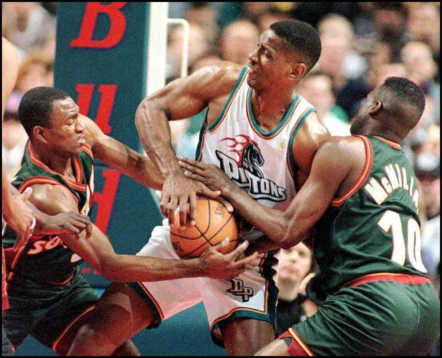 AUBURN HILLS, UNITED STATES: The Seattle Supersonics' Hersey Hawkins (L) and Nate McMillan (R) battle the Detroit Pistons' Otis Thorpe (C) for the ball in the first quarter of their game 16 March at the Palace in Auburn Hills, MI. A jump ball was called on the play. AFP PHOTO/Matt CAMPBELL (Photo credit should read MATT CAMPBELL/AFP via Getty Images)