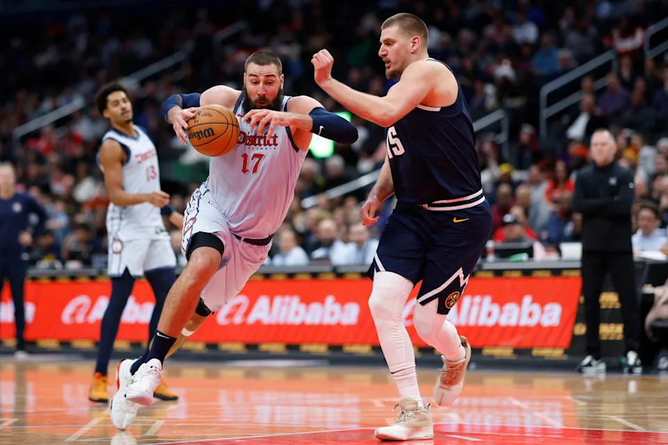 Washington Wizards center Jonas Valanciunas (17) drives to the basket as Denver Nuggets center Nikola Jokic (15) defends in the third quarter at Capital One Arena.Geoff Burke-Imagn Images