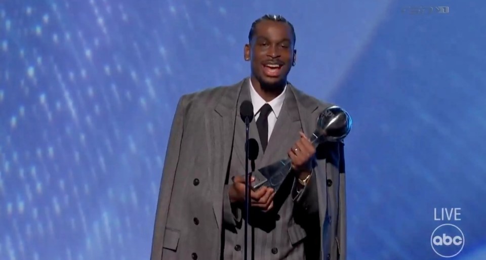 Man in gray suit accepting an award.