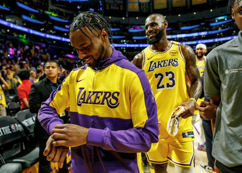 Lakers guard Bronny James, front, leave the court ahead of his father after a victory over Minnesota in last season's opener.