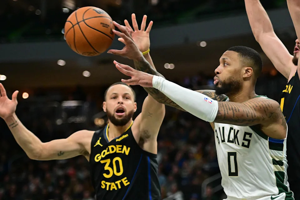 Feb 10, 2025; Milwaukee, Wisconsin, USA; Milwaukee Bucks guard Damian Lillard (0) passes the ball away from Golden State Warriors guard Stephen Curry (30) in the fourth quarter at Fiserv Forum.Benny Sieu-Imagn Images