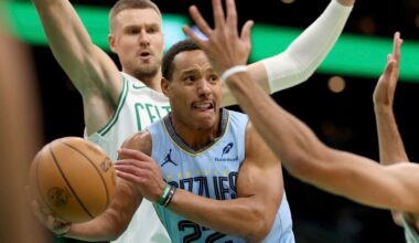 Memphis Grizzlies guard Desmond Bane (22) looks to pass in front of Boston Celtics center Kristaps Porzingis during the first half of an NBA basketball game, Saturday, Dec. 7, 2024, in Boston. (AP Photo/Mark Stockwell)