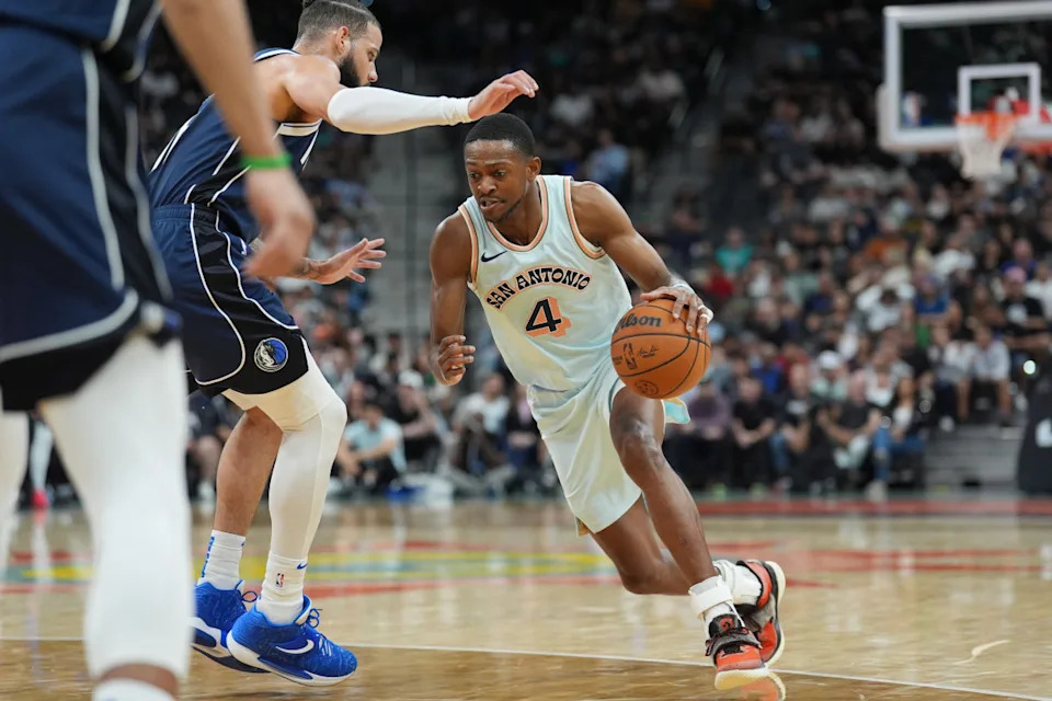 Mar 12, 2025; San Antonio, Texas, USA; San Antonio Spurs guard De'Aaron Fox (4) dribbles against Dallas Mavericks forward Caleb Martin (16) in the first half at Frost Bank Center. Mandatory Credit: Daniel Dunn-Imagn Images© Daniel Dunn-Imagn Images