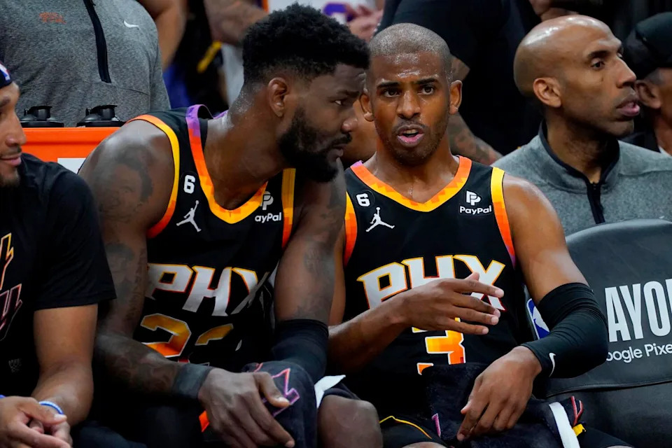 Phoenix Suns guard Chris Paul talks with center Deandre Ayton during a playoff game against the Clippers in April 2023.