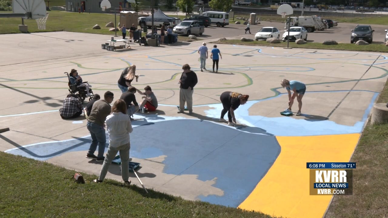 Volunteers paint basketball court at Dike West