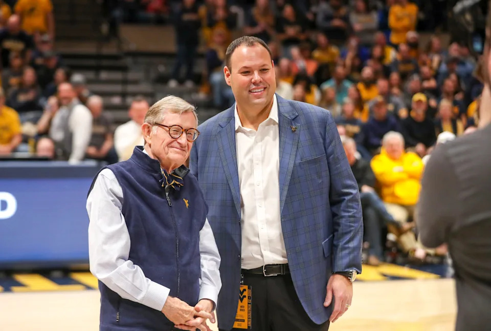 Dec 18, 2022; Morgantown, West Virginia, USA; West Virginia University President Gordon Gee welcomes new West Virginia Mountaineers Athletic Director Wren Baker during the first half against the Buffalo Bulls at WVU Coliseum. Mandatory Credit: Ben Queen-USA TODAY Sports