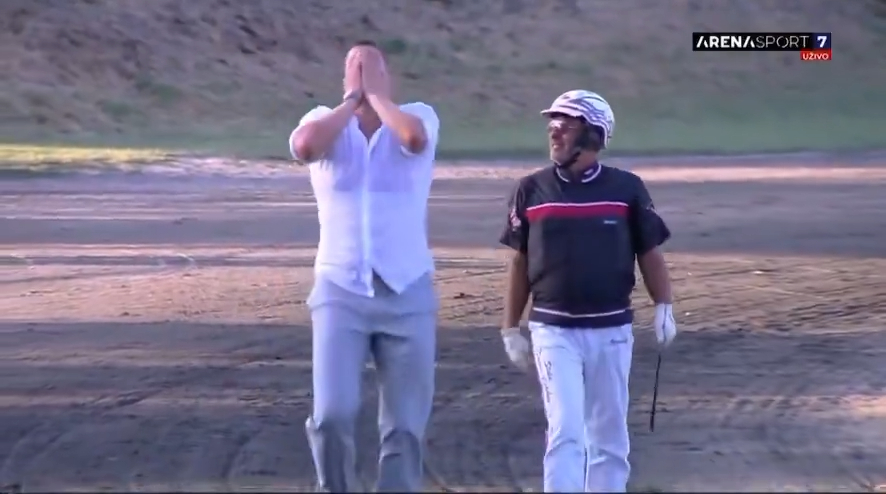 Nikola Jokic reacting emotionally while another man walks nearby.